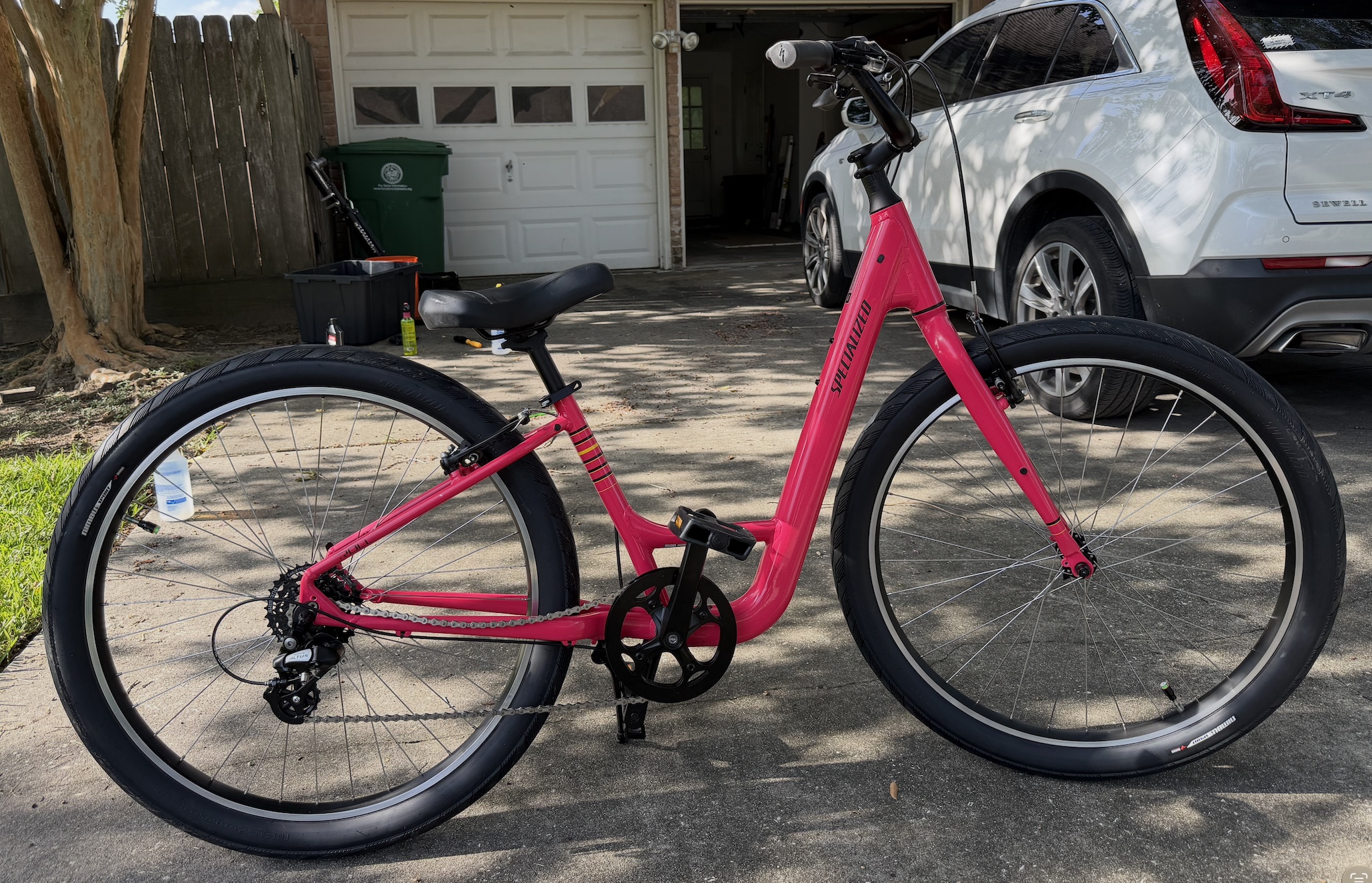 Pink Specialized cruiser after mobile service in a Houston driveway